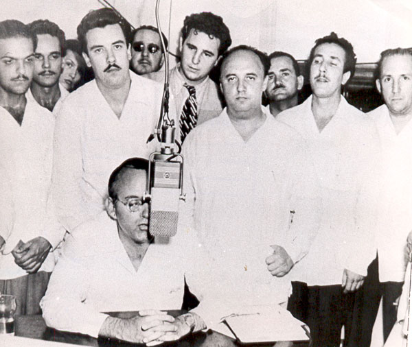 Eduardo Chibás en una de sus alocuciones radiales. De pie, en primera fila (tercero de derecha a izquierda), Roberto Agramonte. Detrás de este, el joven abogado Fidel Castro. (Foto: Autor no identificado) Eduardo Chibás en una de sus alocuciones radiales. De pie, en primera fila (tercero de derecha a izquierda), Roberto Agramonte. Detrás de este, el joven abogado Fidel Castro. (Foto: Autor no identificado)