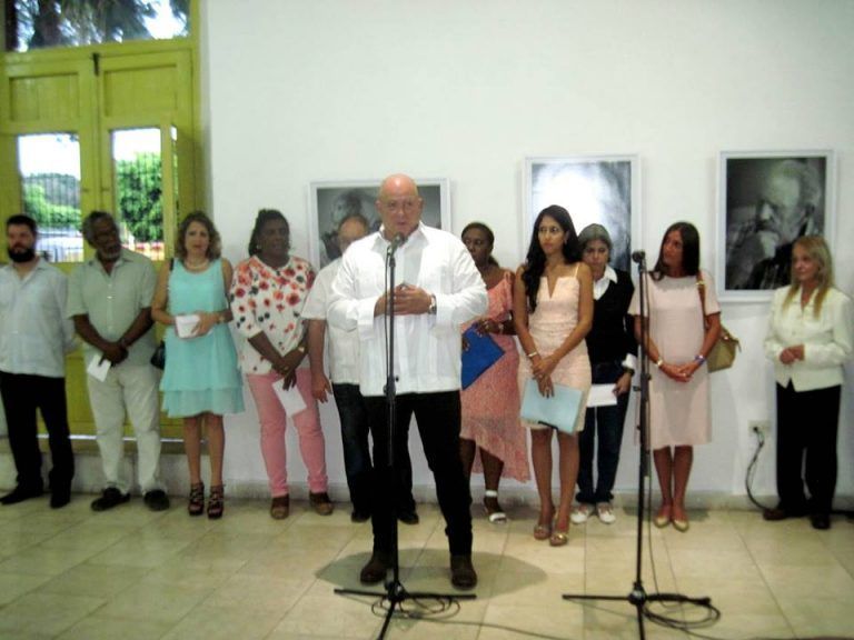 Alex Castro habla en la inauguración de su expo en Santiago. Detrás, las máximas autoridades de Santiago de Cuba, la escritora Teresa Melo y famniliares del Comandante en Jefe. Foto: Miguel Ángel Gaínza